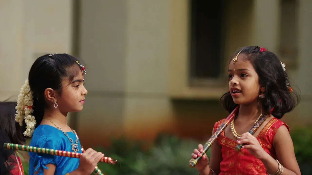 Two girls in traditional chaniya choli holding dandiya sticks for Navratri